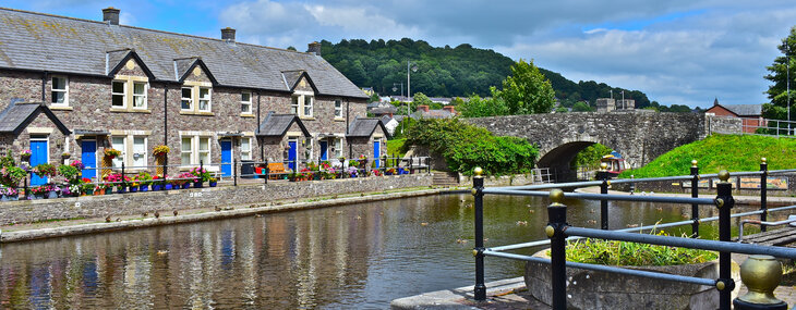 A terraced row of pretty cottages alongside the canal basin of the Monmouthshire and Brecon Canal in Powys, Wales.